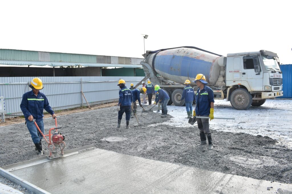 Crew pouring and leveling a new concrete slab